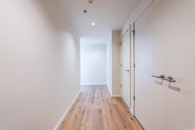 hallway with light hardwood / wood-style floors