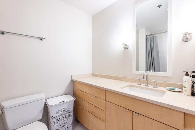 bathroom featuring vanity, toilet, and walk in shower