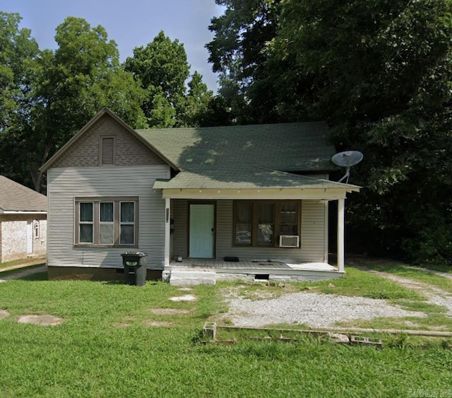 view of front of home with a porch, a front yard, and cooling unit