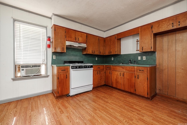 kitchen with a textured ceiling, light hardwood / wood-style flooring, gas range gas stove, and crown molding