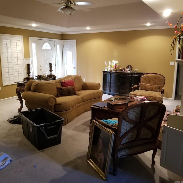 living room with carpet, ceiling fan, a raised ceiling, and crown molding