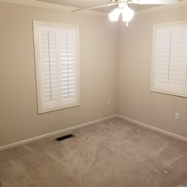 spare room featuring carpet floors, ceiling fan, and crown molding