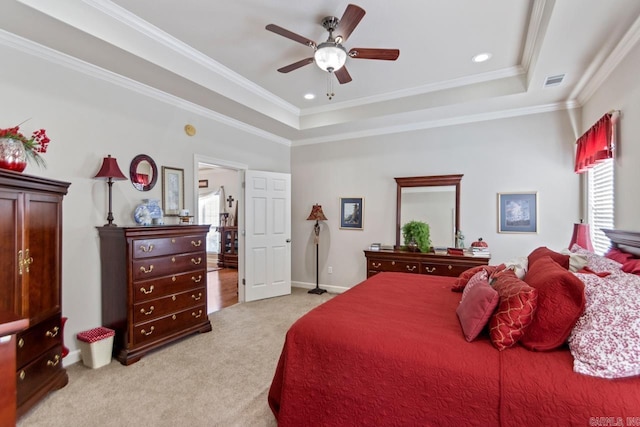 carpeted bedroom featuring ceiling fan, crown molding, and a tray ceiling