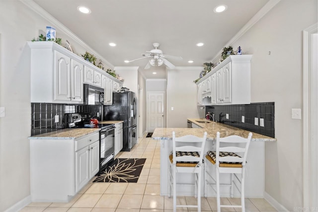 kitchen featuring black appliances, white cabinets, light tile patterned floors, and kitchen peninsula