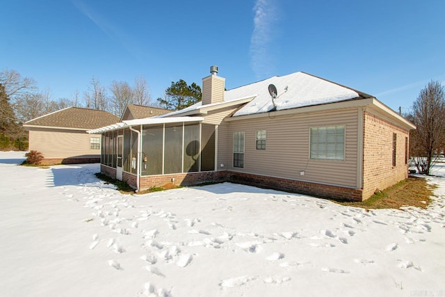 snow covered house with a sunroom