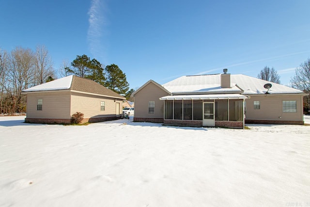 snow covered property featuring a sunroom