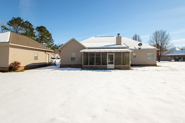 snow covered house with a sunroom