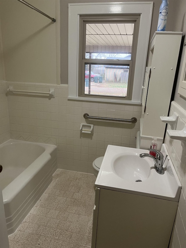 bathroom with tile walls, vanity, tile patterned flooring, and toilet