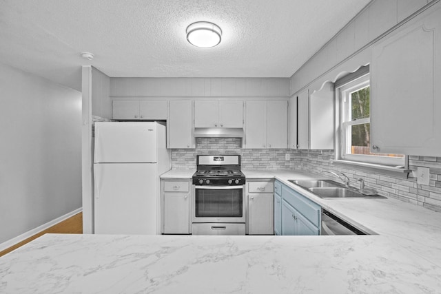 kitchen featuring decorative backsplash, sink, a textured ceiling, and appliances with stainless steel finishes