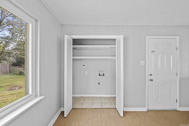 laundry area with hookup for an electric dryer, washer hookup, light wood-type flooring, and a healthy amount of sunlight