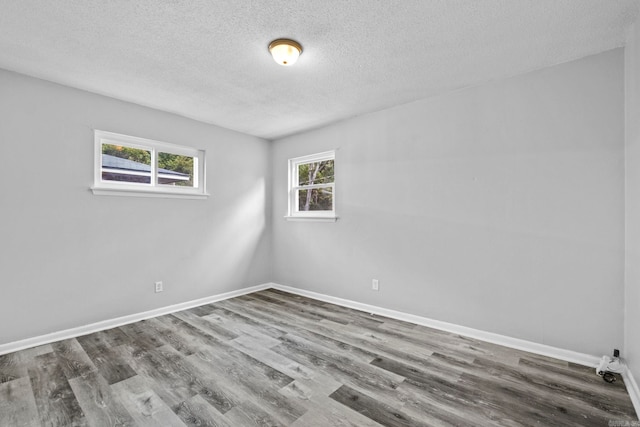 spare room featuring wood-type flooring and a textured ceiling