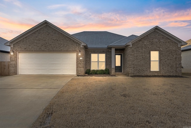 view of front of home with a garage and a yard