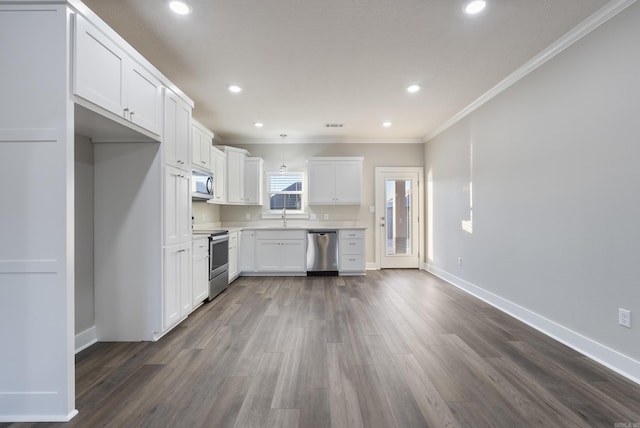 kitchen with dark wood-type flooring, white cabinets, sink, crown molding, and appliances with stainless steel finishes