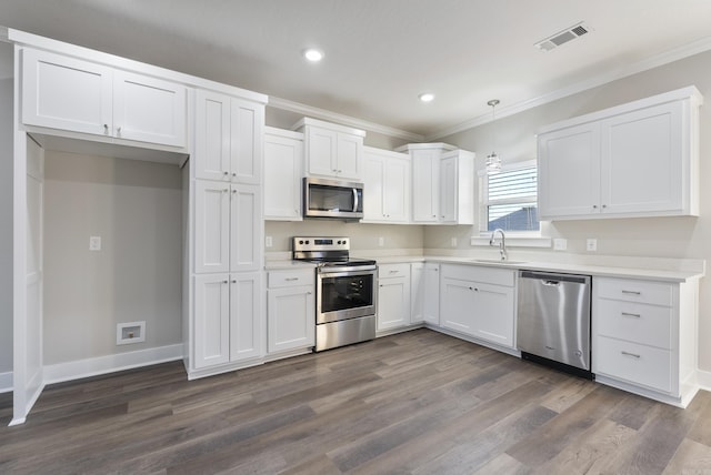 kitchen featuring white cabinets, sink, hanging light fixtures, dark hardwood / wood-style flooring, and stainless steel appliances