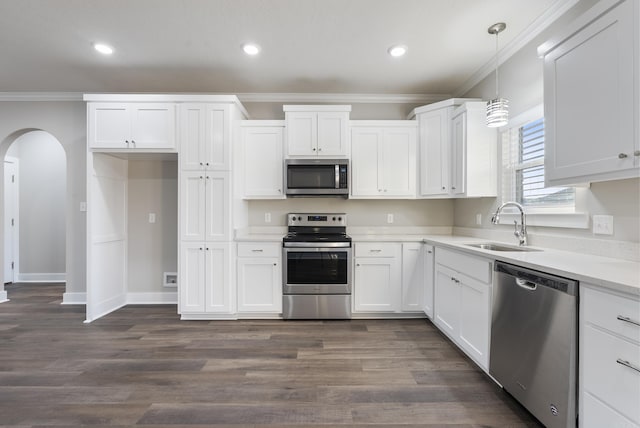 kitchen with pendant lighting, white cabinetry, sink, and appliances with stainless steel finishes