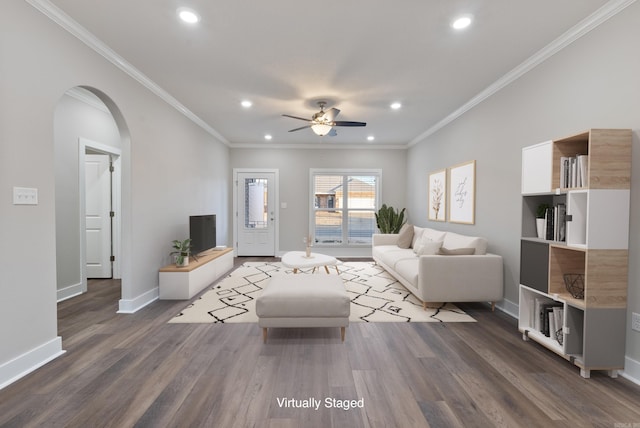 living room featuring dark hardwood / wood-style flooring, ceiling fan, and ornamental molding