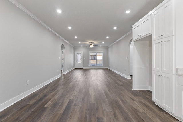 interior space featuring ornamental molding, ceiling fan, and dark wood-type flooring