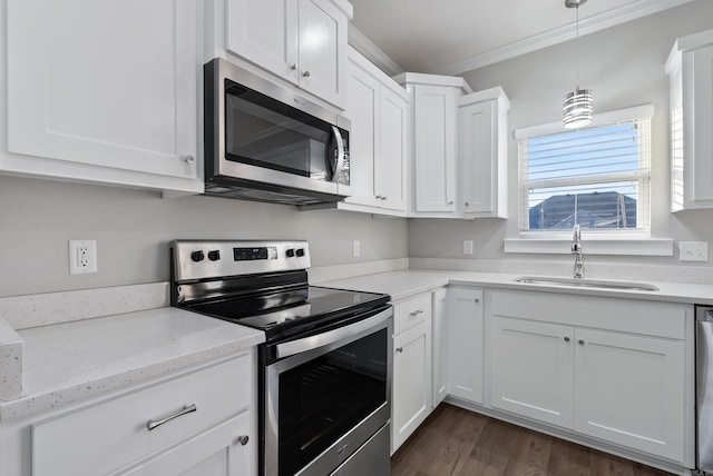 kitchen with white cabinets, sink, ornamental molding, light stone counters, and stainless steel appliances