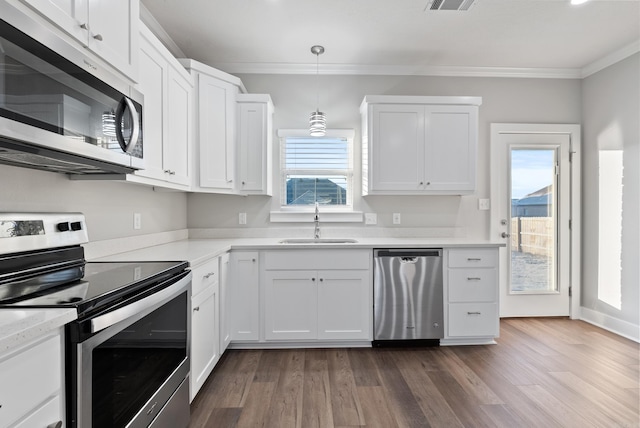 kitchen featuring sink, hanging light fixtures, crown molding, white cabinets, and appliances with stainless steel finishes