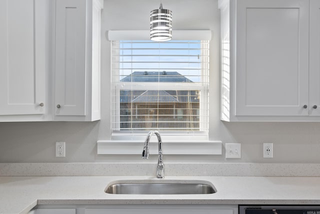 kitchen featuring white cabinetry, sink, dishwasher, and light stone counters