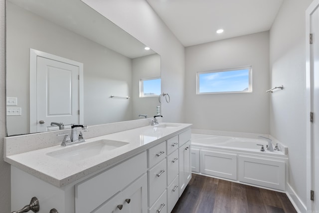 bathroom featuring a bathing tub, vanity, and wood-type flooring