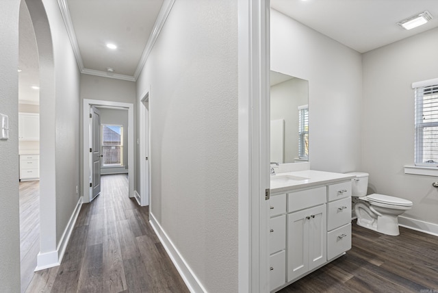 hallway with a healthy amount of sunlight, sink, crown molding, and dark wood-type flooring