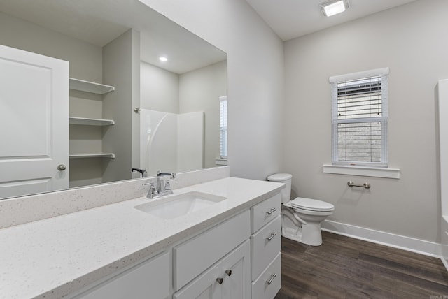 bathroom with a shower, hardwood / wood-style floors, vanity, and toilet