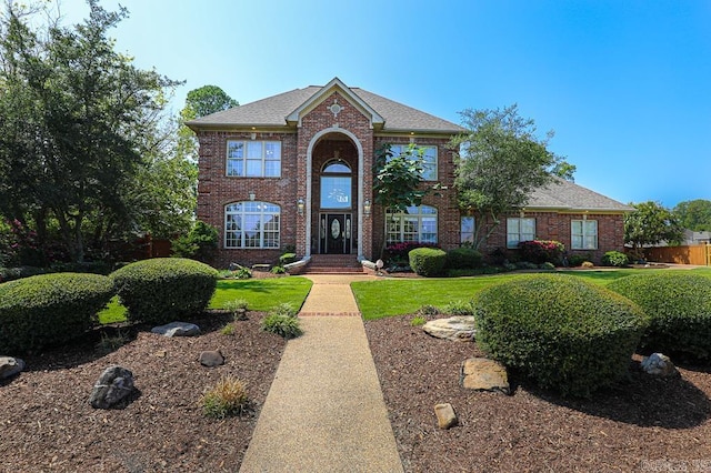 colonial inspired home with a front lawn