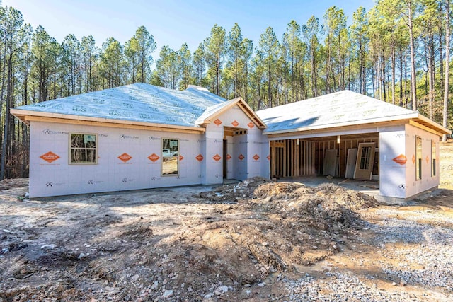 unfinished property with a garage and an outbuilding