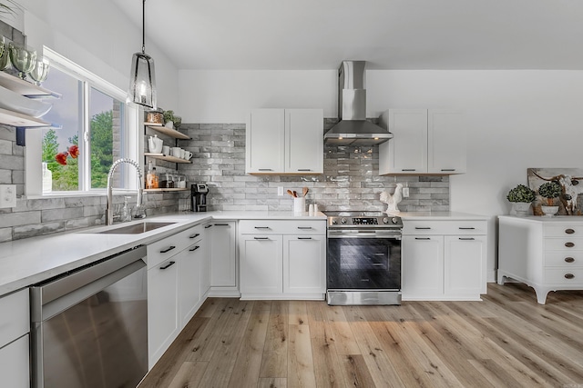 kitchen with sink, wall chimney exhaust hood, decorative backsplash, white cabinetry, and stainless steel appliances