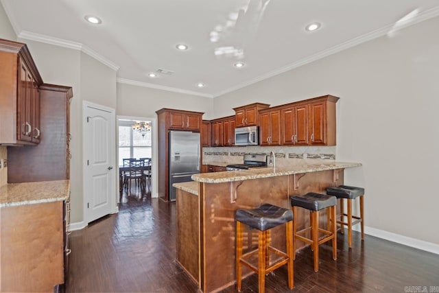 kitchen featuring crown molding, decorative backsplash, appliances with stainless steel finishes, a kitchen bar, and kitchen peninsula