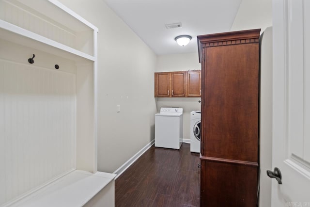 laundry area featuring washing machine and dryer, cabinets, and dark wood-type flooring