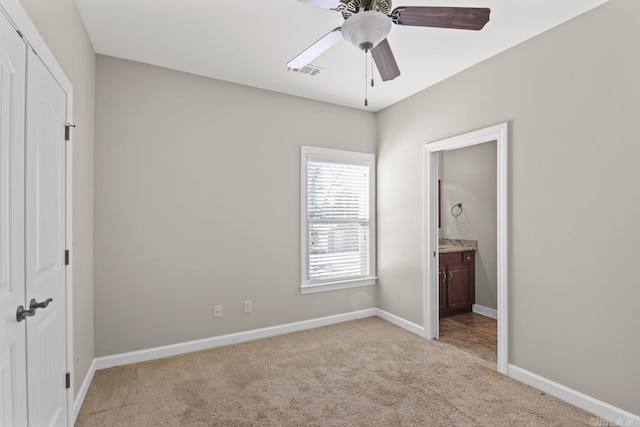 unfurnished bedroom with connected bathroom, a closet, ceiling fan, and light colored carpet