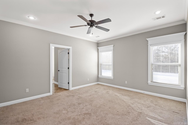 spare room with ceiling fan, a healthy amount of sunlight, ornamental molding, and light carpet