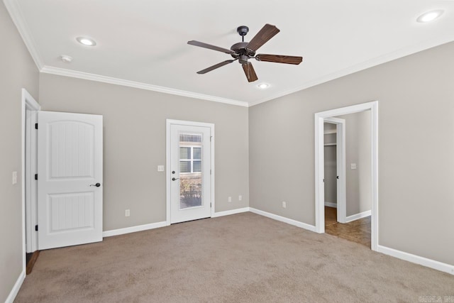 unfurnished bedroom with ceiling fan, a spacious closet, ornamental molding, light colored carpet, and a closet