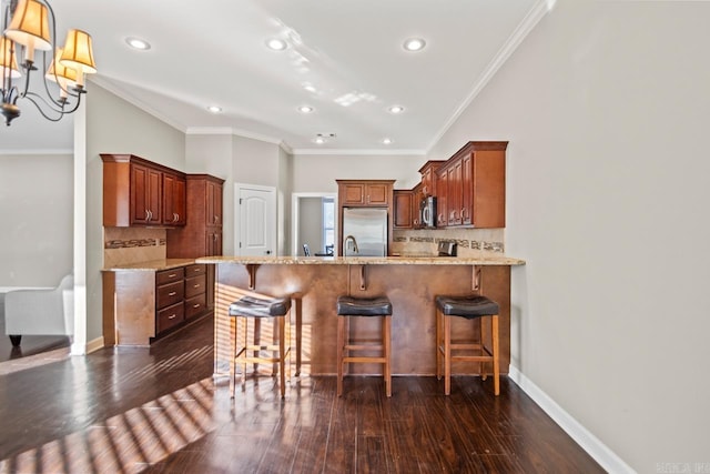 kitchen featuring dark hardwood / wood-style flooring, ornamental molding, appliances with stainless steel finishes, and tasteful backsplash