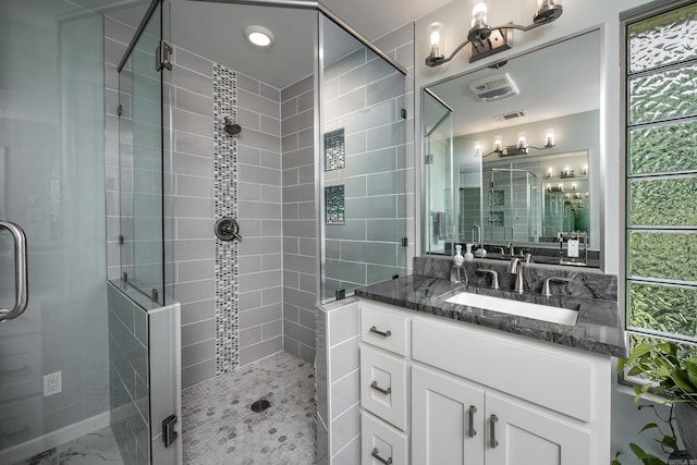 bathroom with a shower with door and vanity