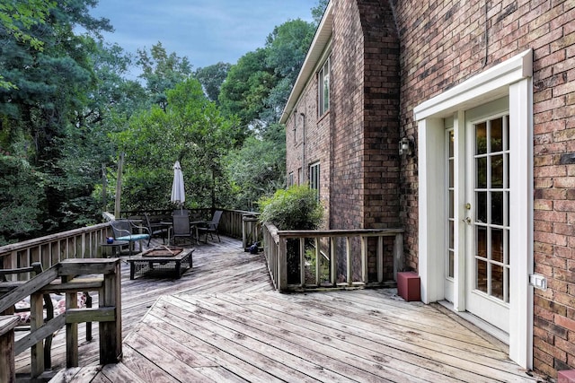 wooden deck featuring an outdoor fire pit