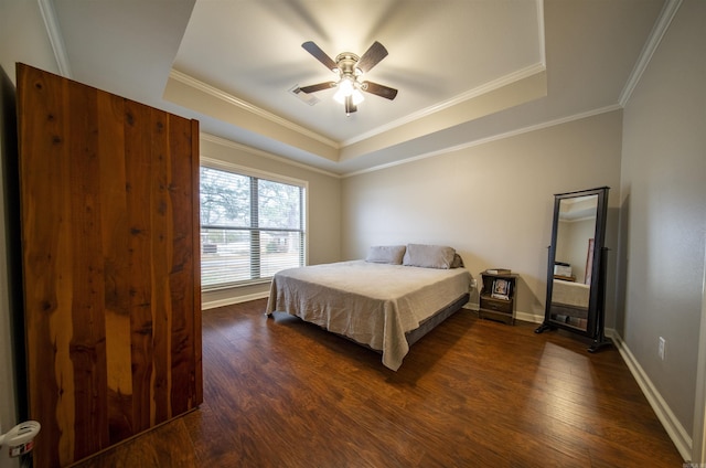 bedroom with dark hardwood / wood-style floors, a raised ceiling, ceiling fan, and ornamental molding