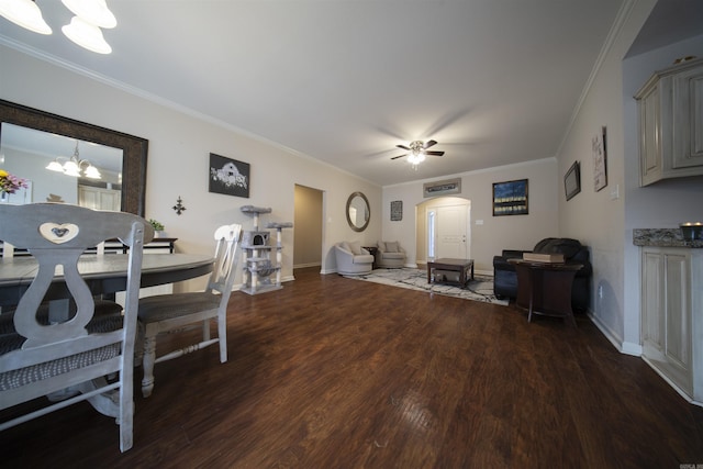 living room featuring ceiling fan with notable chandelier, crown molding, and dark wood-type flooring