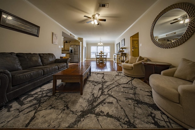 living room featuring crown molding, ceiling fan with notable chandelier, and hardwood / wood-style flooring