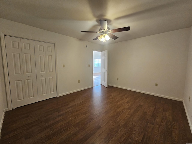 unfurnished bedroom featuring ceiling fan, a closet, and dark wood-type flooring