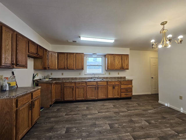 kitchen with dark wood-type flooring, sink, a chandelier, and decorative light fixtures