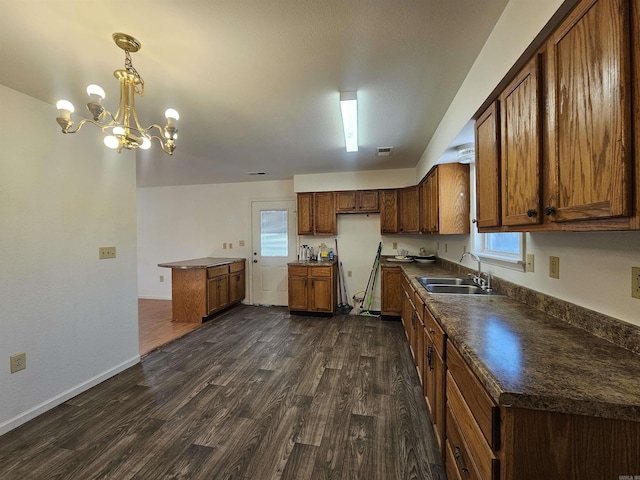 kitchen with sink, hanging light fixtures, plenty of natural light, dark hardwood / wood-style flooring, and a chandelier