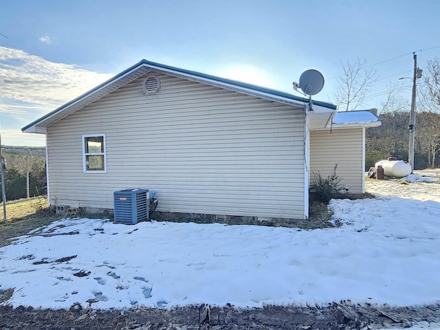 view of snow covered exterior featuring cooling unit