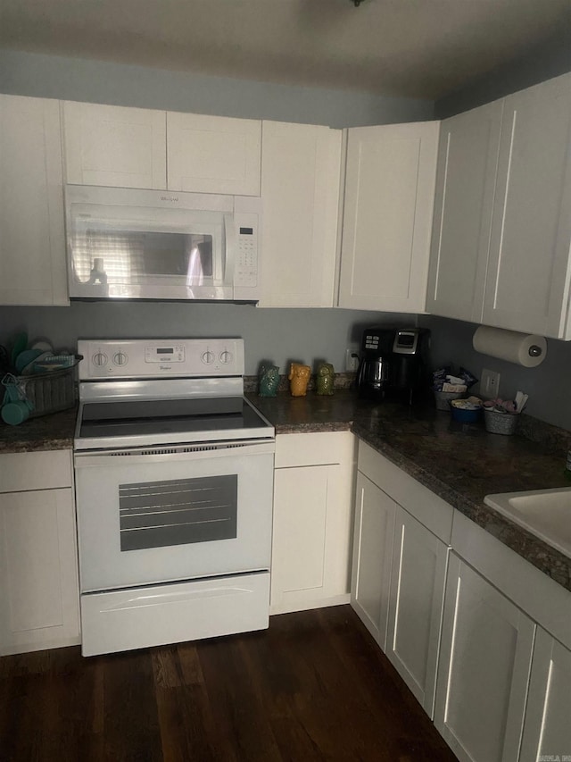 kitchen featuring white cabinetry, dark wood-type flooring, white appliances, and dark stone counters