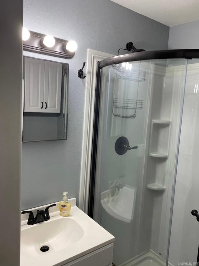 bathroom featuring vanity and a shower with door