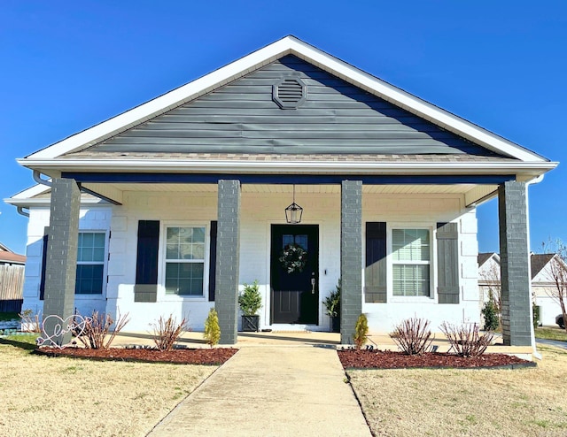 view of front of home with a front yard and covered porch