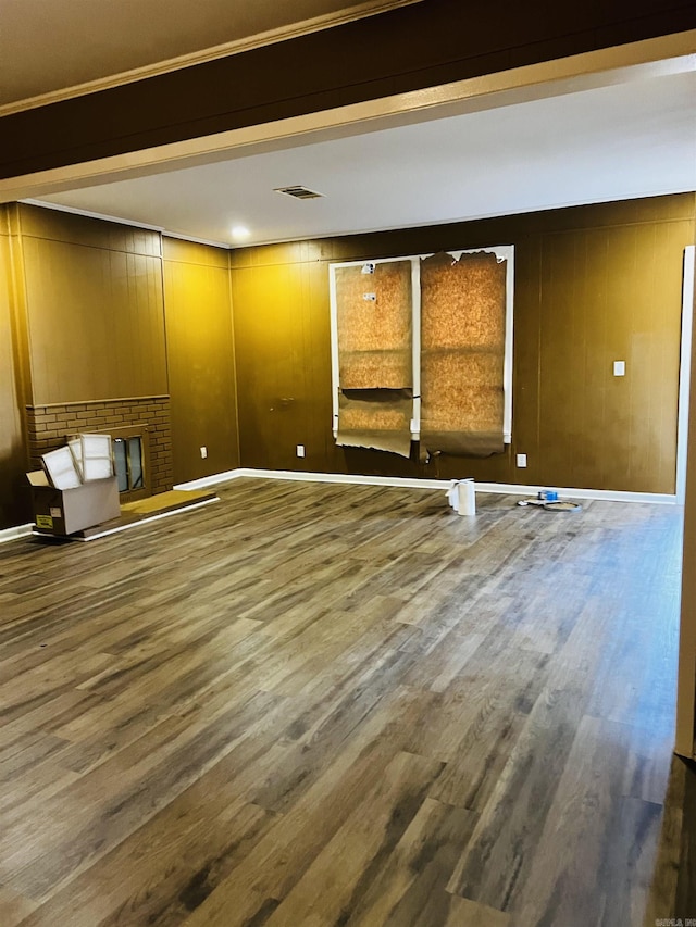 unfurnished living room with dark hardwood / wood-style flooring and wood walls