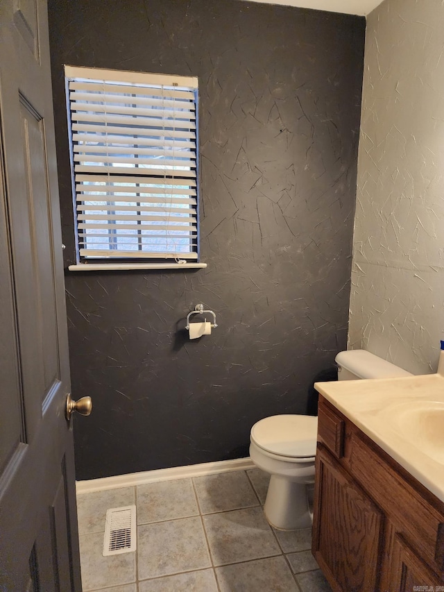 bathroom with toilet, tile patterned floors, and vanity